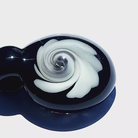 Detailed view of handmade black and white swirl glass pendant with glossy finish, ideal for unique jewelry gift ideas and art lovers.