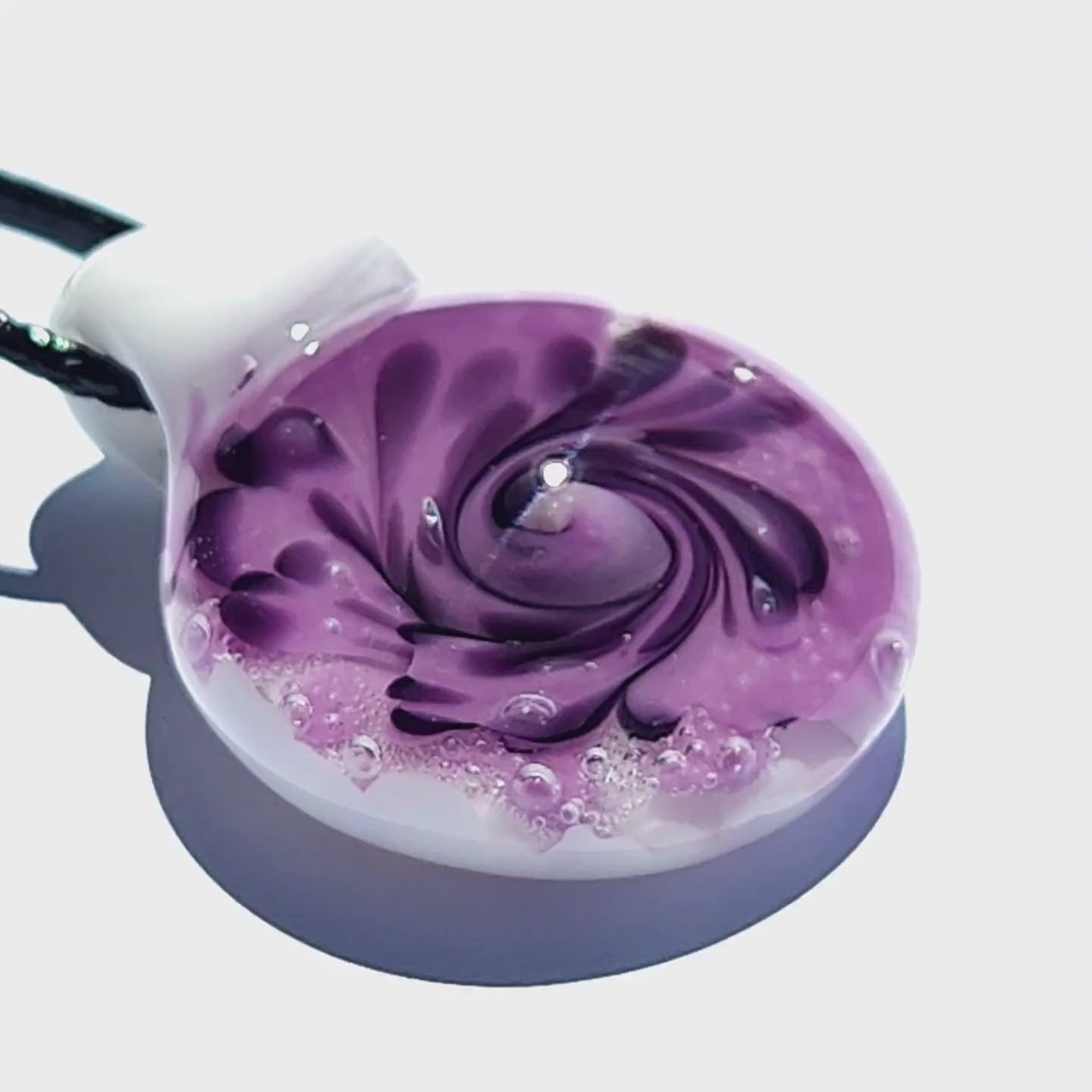 Unique purple spiral glass pendant necklace with white and black accents, handmade with bubble details, shown on a white background.