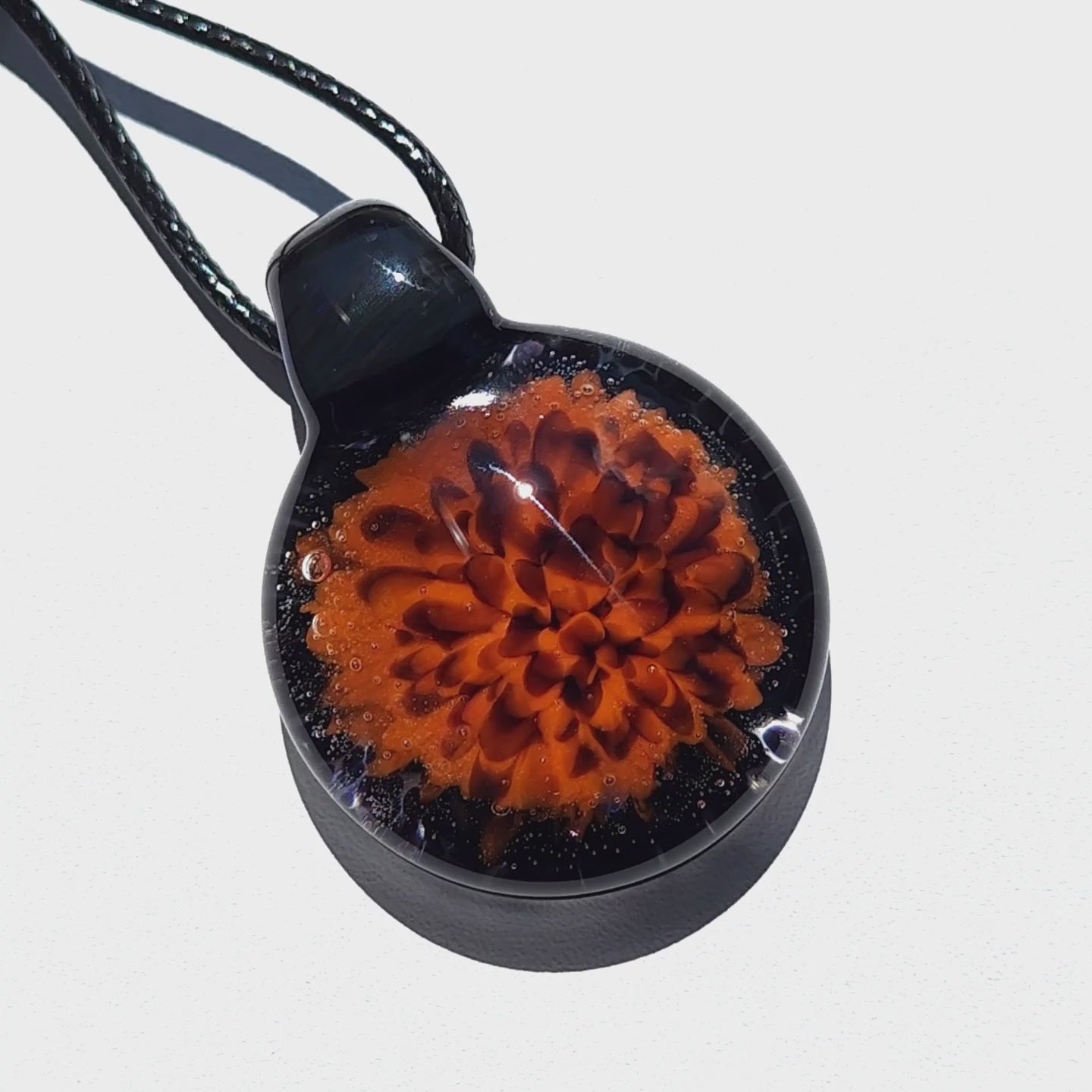 Fiery Flame Glass Pendant with vibrant orange floral design and crushed black glass, perfect for fall fashion. Handmade blown glass charm.