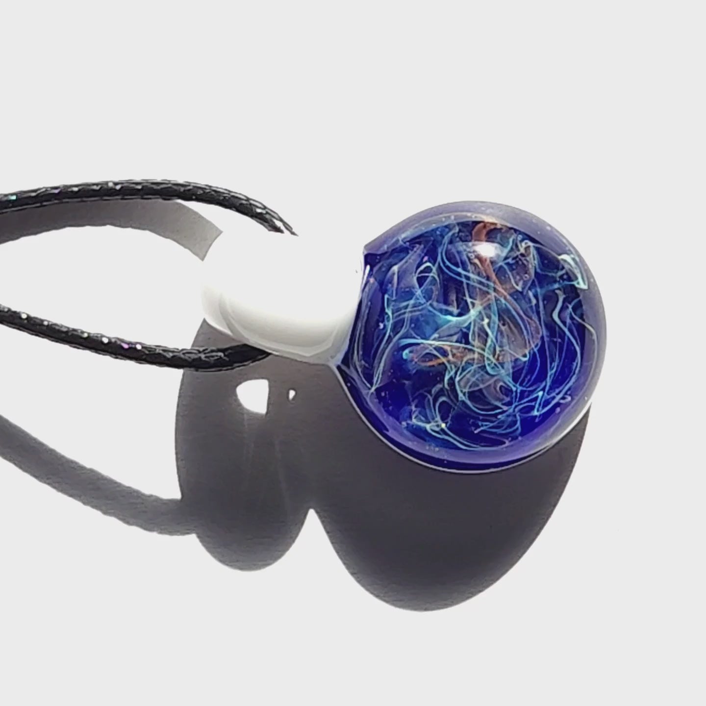 Artisan Deep Blue Galaxy Pendant Necklace with vibrant swirling patterns, handmade glass jewelry on a white reflective background.