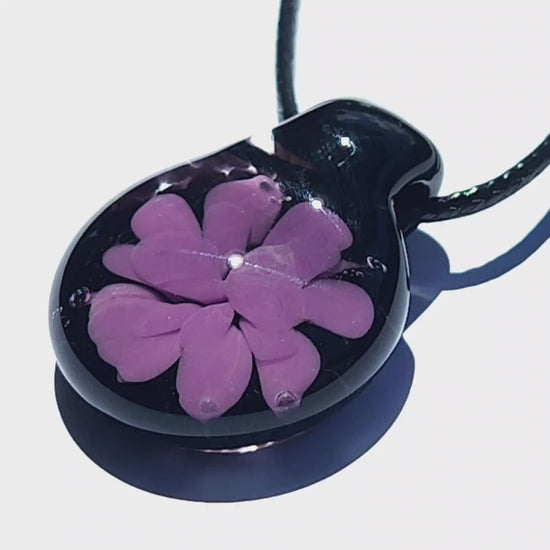 Glossy black glass pendant featuring a purple flower design, minimalist and handcrafted for a unique statement necklace.
